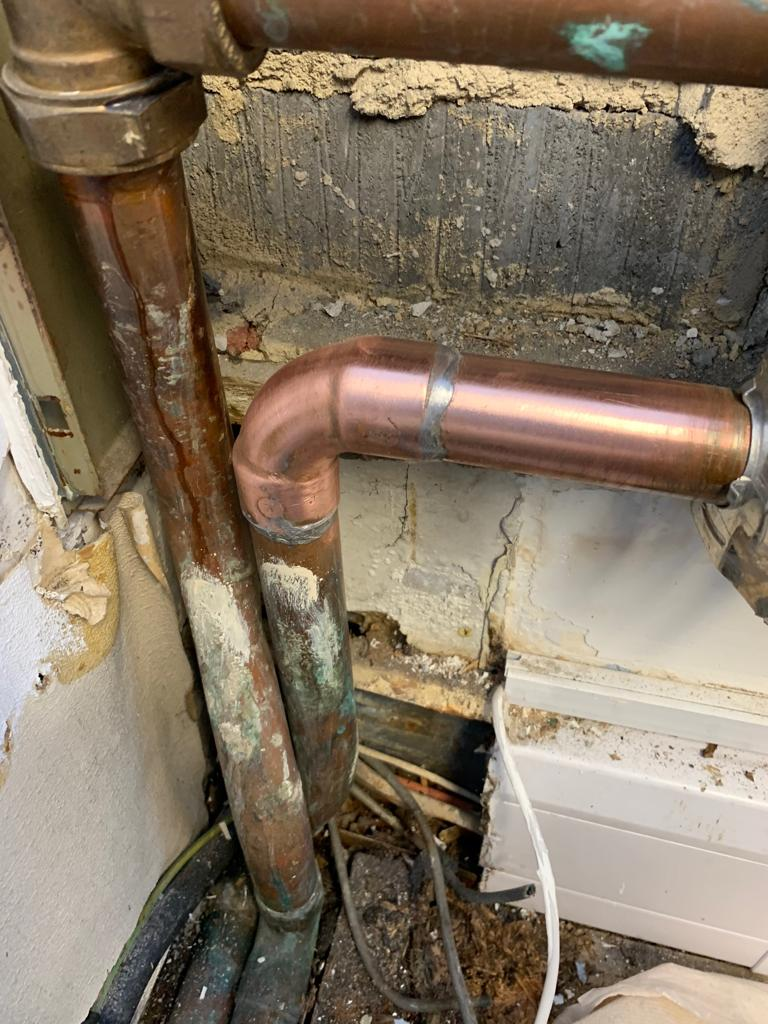 A copper pipe leaking from a badly soldered joint required repair after it was noticed that water damage had been caused to wooden floorboards