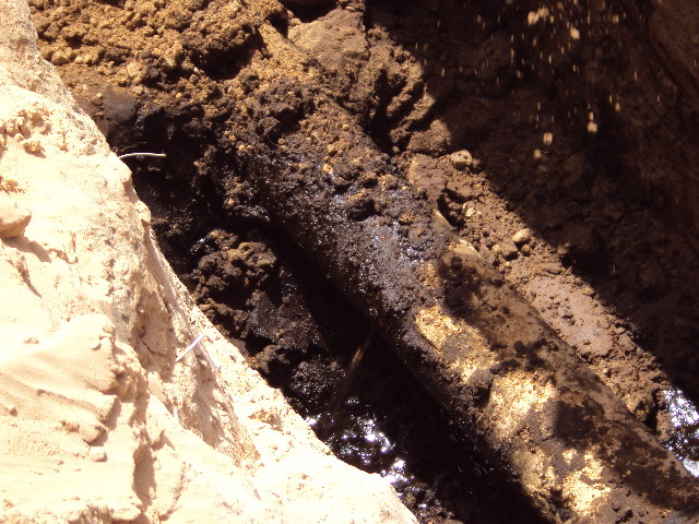 An underground oil line leaking in Libya prior to undergoing repair using SylWrap Pipe Repair products