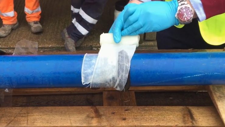 SylWrap HD is applied to a steel pipe under 6 bar pressure as part of a demonstration showing how to fix a leaking pipe with a SylWrap Pipe Repair Kit