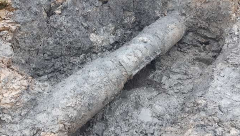 A leaking effluent steel pipe requiring repair under salt marshes