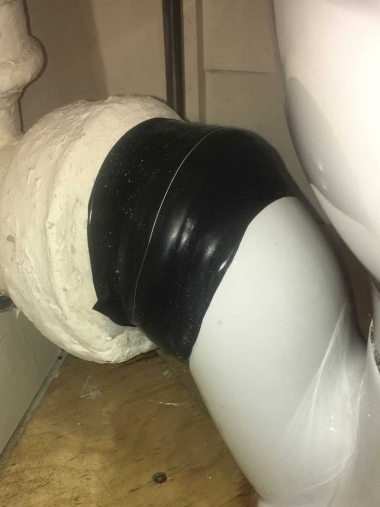 Wrap & Seal Pipe Burst Tape wrapped around a porcelain toilet soil pipe to repair a hairline crack